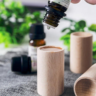 versement d'une goutte d'huile essentielle dans le diffuseur d'Huiles Essentielles en Bois 